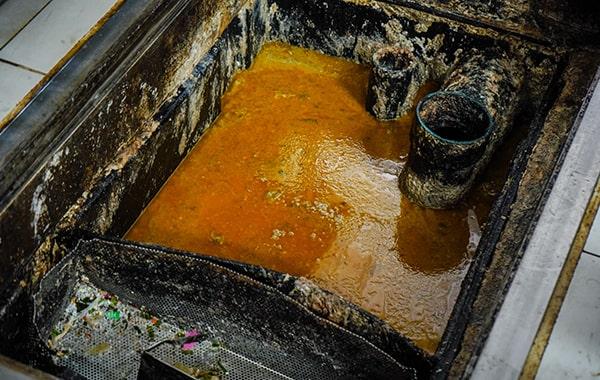 throughout grease trap cleaning, the trap is cleared, scraped, and washed to remove built-up grease and solids